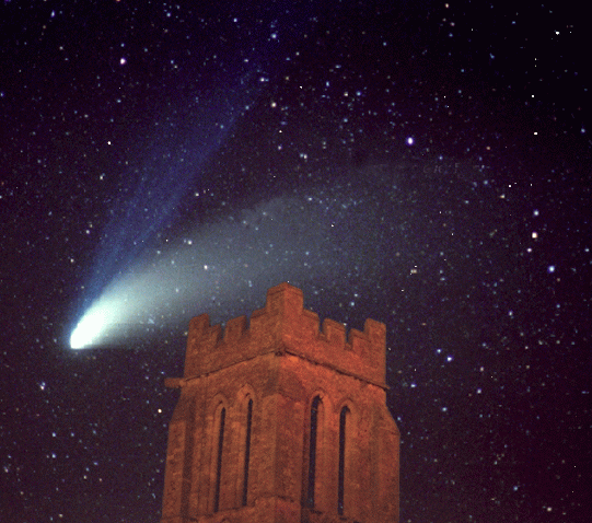 Comet Hale-Bopp is shown streaking across the sky, with stars scattered across the sky in the background and a church building in the foreground.
