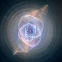 Nebula #6 (the Cat's Eye) is shown with a new set of camera filters; displaying complicated shells of blue, white, and orange light surrounding a bright white star.