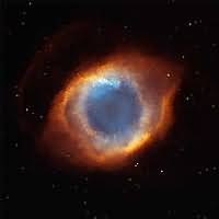 The first in a mosaic of 12 nebula images shows a light blue-white central region surrounded by orange and reddish oval shells. The overall appearance of the Helix Nebula is of a giant eye looking out towards us inquisitively.
