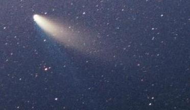 Comet Hale-Bopp, with a bright core and two trailing tails, observed against the night sky.