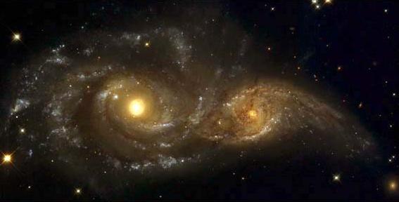 Two neighboring spiral galaxies, so close together that their spiral arms overlap.
