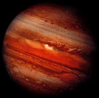 Jupiter, with many horizontal bands of clouds and a gigantic storm system named the Great Red Spot.