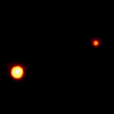 Pluto and its moon Charon, so far away they appear as bright dots.