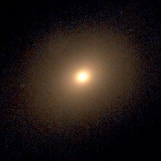 Telescope image of elliptical galaxy NGC 4406, with amber gold colors throughout and a bright central core.
