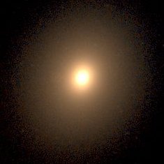 Telescope image of elliptical galaxy NGC 4472, with a small bright golden core surrounded by a bright fainter halo of stars..