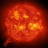 Bright red, orange, and yellow image of the Sun, showing huge ribbons of material streaming off of the surface